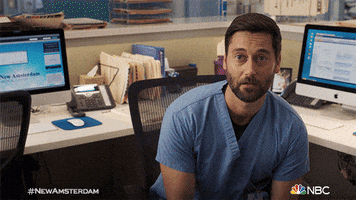 TV gif. Ryan Eggold as Dr. Max Goodwin on New Amsterdam sits in an office chair and looks up. He tilts his head and smirks.