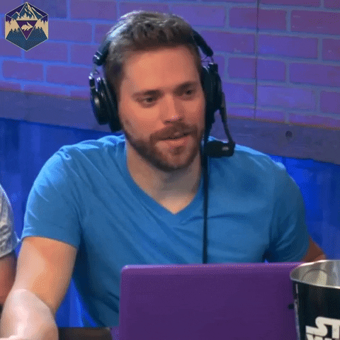 a man wearing headphones is sitting in front of a laptop computer .