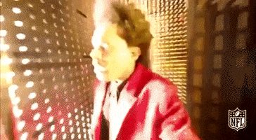 Celebrity gif. The Weeknd dressed in a red blazer, traveling frantically and looking lost in a golden, brightly lit maze of mirrors.