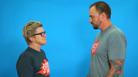GIF of two guys talking while a third in a bird headdress walks past with the text "Tangent Alert" written on it.
