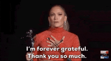 Celebrity gif. Jennifer Lopez holds a CFDA award trophy in her hands while talking into a microphone. She has her hand placed over her heart with teary eyes. She then grabs her trophy with both hands, and thrusts it up to emphasize its importance. She then turns to leave the stage with an earnest smile on her face. She says, “I'm forever grateful. Thank you so much.”