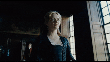 Movie gif. We look up at Emma Stone as Abigail in The Favorite as she cringes with uncertainty while walking down a cavernous hallway.