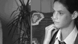 Gif preto e branco, mulher levantando a mão do lado da boca e colocando a língua na bochecha simulando sexo oral