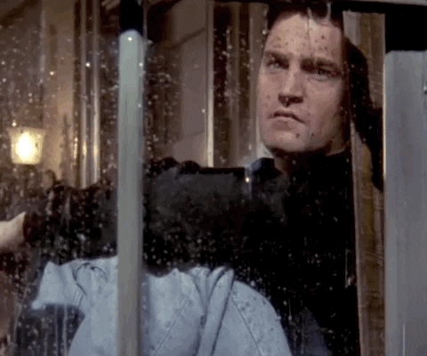 Vrienden gif. Matthew Perry als Chandler peinzend uit het raam staren naar de regen.