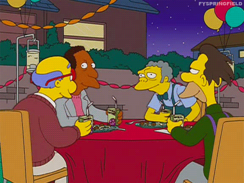 Postavy ze seriálu The Simpsons, sedící u stolu a ťukajícími si džusy k přípitku. 