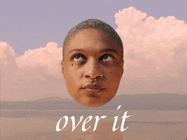 Video gif. Woman’s head floats over a cloudy, mountainous landscape as she rolls her eyes in annoyance. Text, “Over it.”
