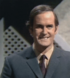 Celebrity gif. A young John Cleese smiles and raises his hand in the OK symbol. 