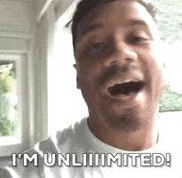 Sports gif. Russell Wilson from the Denver Broncos looks at us with a smile and says, “I'm unlimited!”