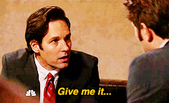Parks and Recreation gif. Paul Rudd as Bobby Newport looks at another suited-up man tauntingly and saying, "Give me it... give me it! C'mon, give me it!" which appears as text.