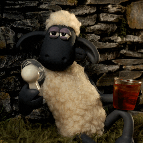 Cartoon gif. Shaun the Sheep lazily leans on a stone wall in the grass. He holds a mini electric fan in one hand and a glass of iced tea in the other. He “oohs and Ahhs’ as the fan blows in his face. 