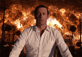 Digital art gif. Jon Hamm as Don Draper, eyes closed in relaxed meditation, his face melting into an untroubled smile, an entire city exploding in flames behind him.