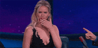Celebrity gif. Jennifer Lawrence wears a lowcut black dress and covers her mouth with her manicured hand, looking pleasantly puzzled and intrigued.