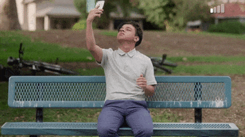 TV gif. Jason Genao as Ruby in On My Block. They lift their phone to the sky in an attempt to find signal, but their efforts are futile. They look dejected as their shoulders sag and they aggressively shake the phone, trying to get it to work.