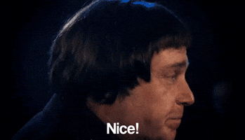 Video gif. A man turns towards us abruptly and says, "Nice!"