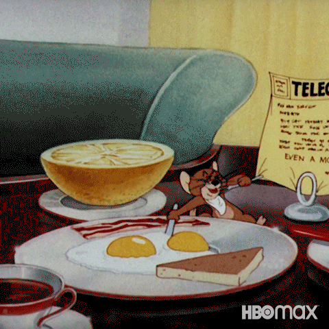 Cartoon gif. Jerry the mouse on Tom and Jerry sits next to a sliced lemon in front of a large plate of breakfast. He quickly cuts up the sunny side up egg and eats it. He picks up the long piece of bacon and chomps on it rapidly until it disappears.