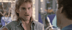 Movie gif. An impressed Seann William Scott as Peppers from Old School points at a dart in the neck of a woozy man in the foreground. He exclaims: Text, "Yes! That is awesome."