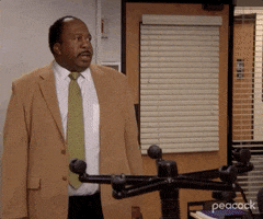 The Office gif. Leslie David Baker as Stanley Hudson hesitates before walking huffily out of the office and saying, "Goodnight," which appears as text.