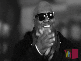 Celebrity gif. Wearing sunglasses, CeeLo Green bites his lip and claps enthusiastically. In the bottom corner we see the logo for Vh1.