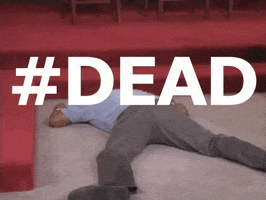 Video gif. A man lays on the floor, limp and lifeless. The text, “#dead” flashes over his corpse-like body. 