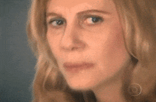 Video gif. We zoom in on the face of a woman with a confused expression and eyes that shift slowly as if she's deep in thought.
