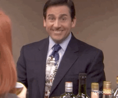  We zoom in on Steve Carell as Michael Scott, grins as he gives us finger guns.