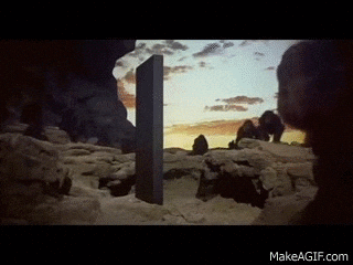 microservices : Gif tiré de l'introduction du film "2001, l'odyssée de l'espace", où des hommes primitifs s'agitent devant un monolithe noir. 