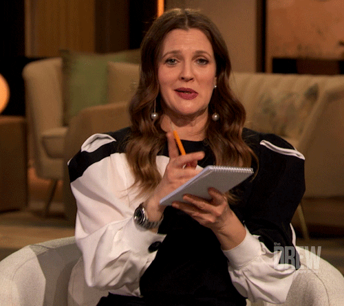 Gif of Drew Barrymore with a notepad and pencil gettign ready to write