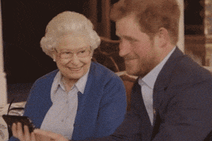 Celebrity gif. A grinning Prince Harry turns away from Queen Elizabeth II to give us a mic drop gesture. Text, "Boom."