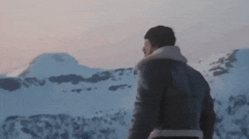 Movie gif. Sylvester Stallone as Rocky in Rocky is on top of a snowy mountain and he throws his arms in the air, cheering for himself.