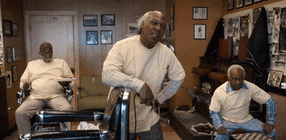 Movie gif. Eddie Murphy and Arsenio Hall as the old men in the barbershop stand with amused smiles on their faces and then burst into laughter.