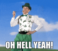Video gif. A man wearing a shamrock vest, green pants, and green hat does a little jig while smoking a pipe. Text, "Oh hell yeah!"