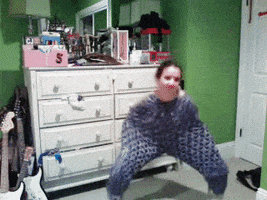 Video gif. A woman dances awkwardly having pulled her pajama pants all the way up to her neck. 
