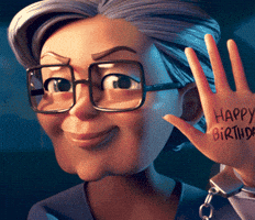 Video game gif. Grandma Ursula from Merge Mansion looks at us with a cheeky smile and holds up a hand with the text, “Happy Birthday!” written on it.