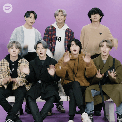 Celebrity gif. BTS waves and smiles at us, saying hi while smiling.