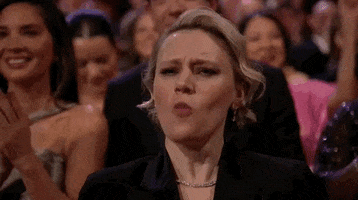 Oscars 2024 GIF. Kate McKinnon, at the Oscars, loudly cheers “Woooooo!”