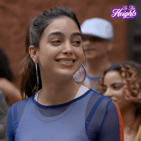 Movie gif. Melissa Barrera as Vanessa in In the Heights smiles broadly as she nods her head affirmatively.