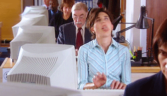 Video gif. White woman furiously typing at a desk with eyes closed shakes her head so intensely that her fully extended tongue wags back and forth. 
