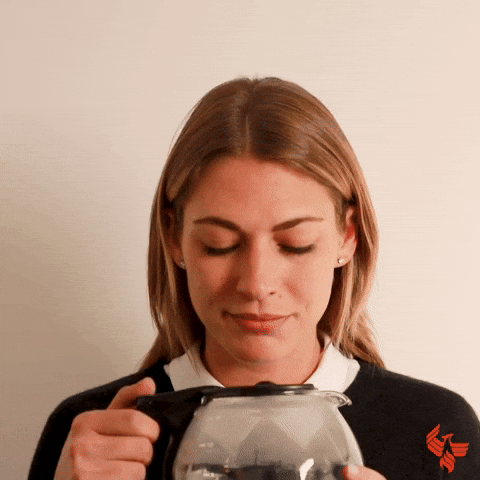 Video gif. A woman holds a pot of coffee and pops opens the lid while staring into it. She lifts it to her mouth and chugs directly from the pot.