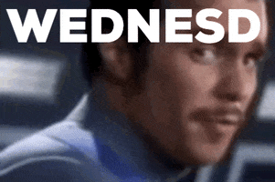 Celebrity gif. Close-up of Sam Rockwell, who smiles and leans his head back with the text “WEDNESD” at the top, jerking his head back as if commanding the camera to zoom out. He points at the camera, the text changing to "AYYYYYY.”
