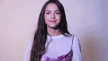 Celebrity gif. Actress Olivia Rodrigo raises both thumbs gestures in enthusiastic approval. 