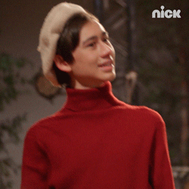 TV gif. Wearing a beret and turtleneck, Nathan Janak playing Oliver on Drama Club holds his head back in disbelief as if to say, “excuse me?”