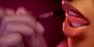 Music video gif. A scene from Gold Digger by Jamie Foxx and Kanye West. We're zoomed in on a pair of lips that are juicy and ultra glossed. Their tongue comes out slightly and licks their teeth sexily. 