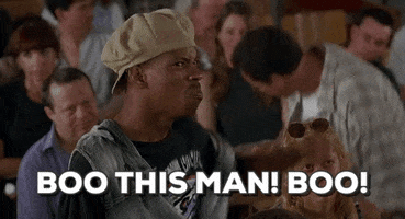 Movie gif. A scene from the movie Half Baked. A man stands with a disgruntled looking crowd sitting behind him. He points angrily as if offended at someone, saying., “Boo this man! Boo!” He then grabs the hat off of his head and chucks it. The crowd behind him starts to get up and follow his protest.