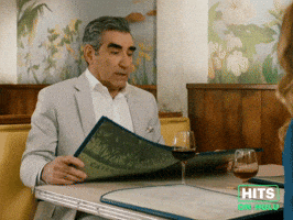 Sponsored GIF. Eugene Levy sits in a restaurant booth, looks up from an open menu as if realizing something is amiss, takes a breath and closes it and suggests, “Ok why don’t we all take a deep breath here” in an attempt to reassure everyone despite his own shock