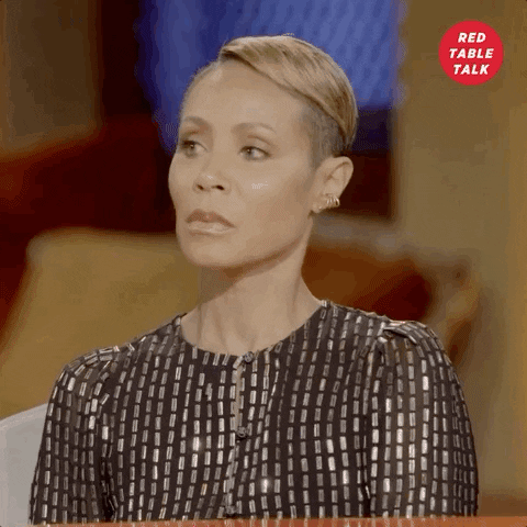 Celebrity gif. Jada Pinkett Smith on Red Table Talk is attentive, taking a breath and resting her head on her hand.