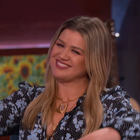 TV gif. Kelly Clarkson on her daytime talk show has her eyes closed with a smile on her face. She Hugs the air and then looks at us still grinning. 