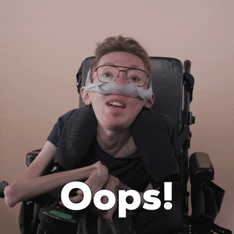 Reaction gif. A mobility-impaired white man using a power chair, a ventilator, and wearing retro-crossbar glasses says with the postured innocence of a child, "Oops!"
