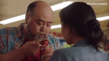 TV gif. Actor Paul Sun-Hyung Lee as Mr. Kim in Kim's Convenience eats cold ravioli straight from the can with a plastic knife. 