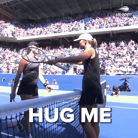 Sports gif. Iga Swiatek runs up to hug another player over the net at the US Open like they just finished a match. Text, "Hug me."