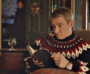 Martin Freeman playing "Dr. Watson" in Sherlock sits reading a book, yet looks up confused when Sherlock walks up in the background.